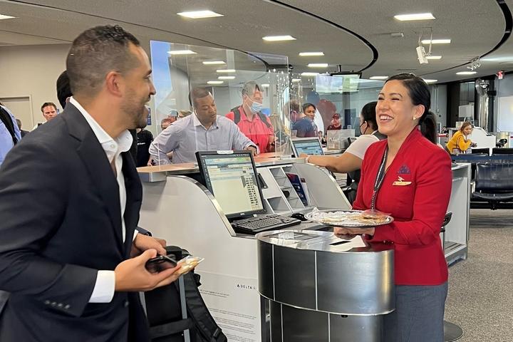 Red Coat Erika Robalino serves a customer. 