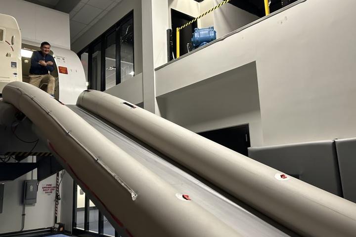 Todd O., Delta's most frequent flyer, prepares to take the plunge down the slide after an emergency flight simulator test. 